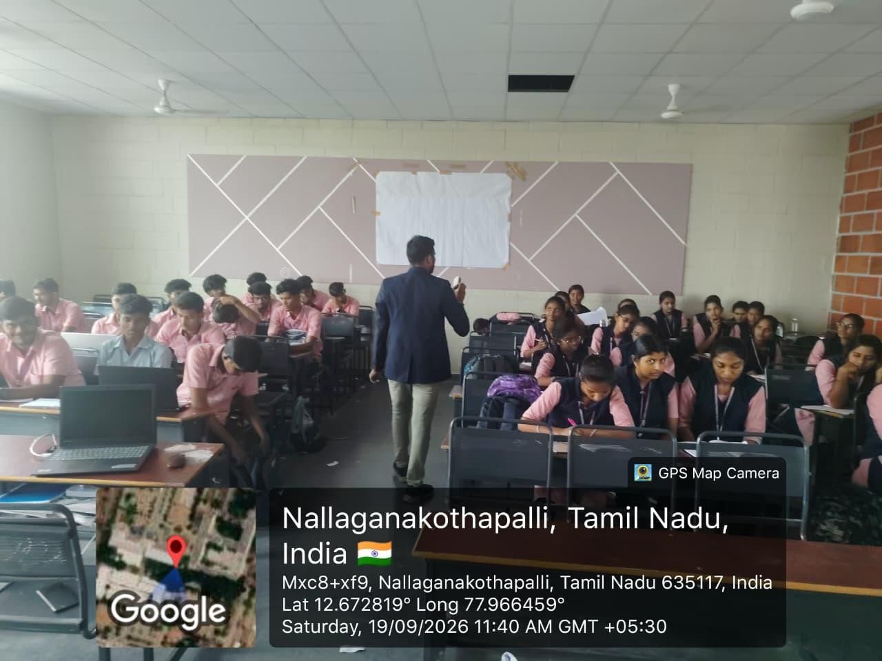 A trainer addressing students seated with laptops during the Awake aptitude training.