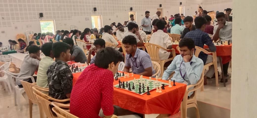 Rows of players at chess tables filling a large hall during a tournament