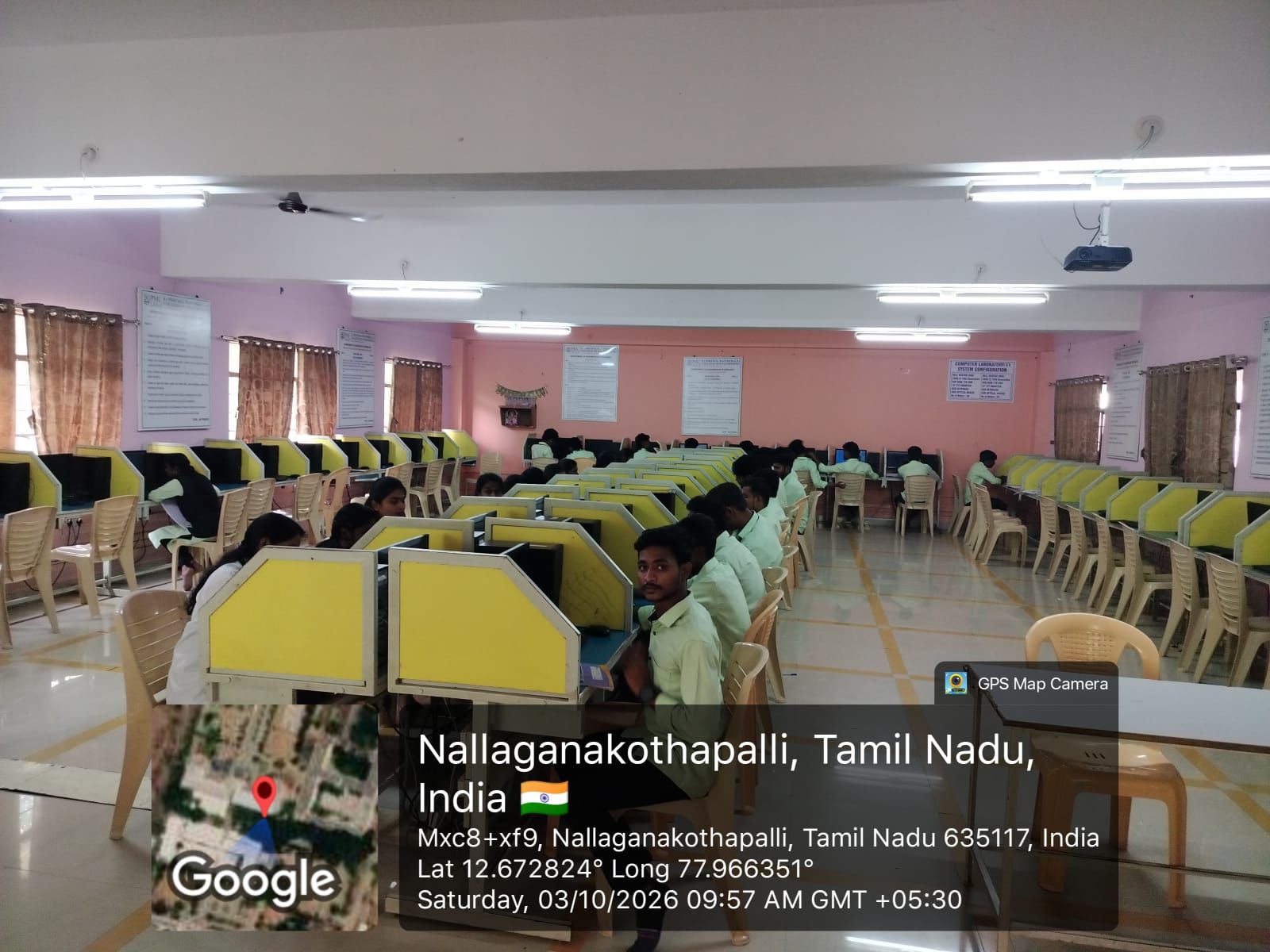 Database Design & Management Laboratory: rows of students at computer workstations with yellow partitions in a large hall.