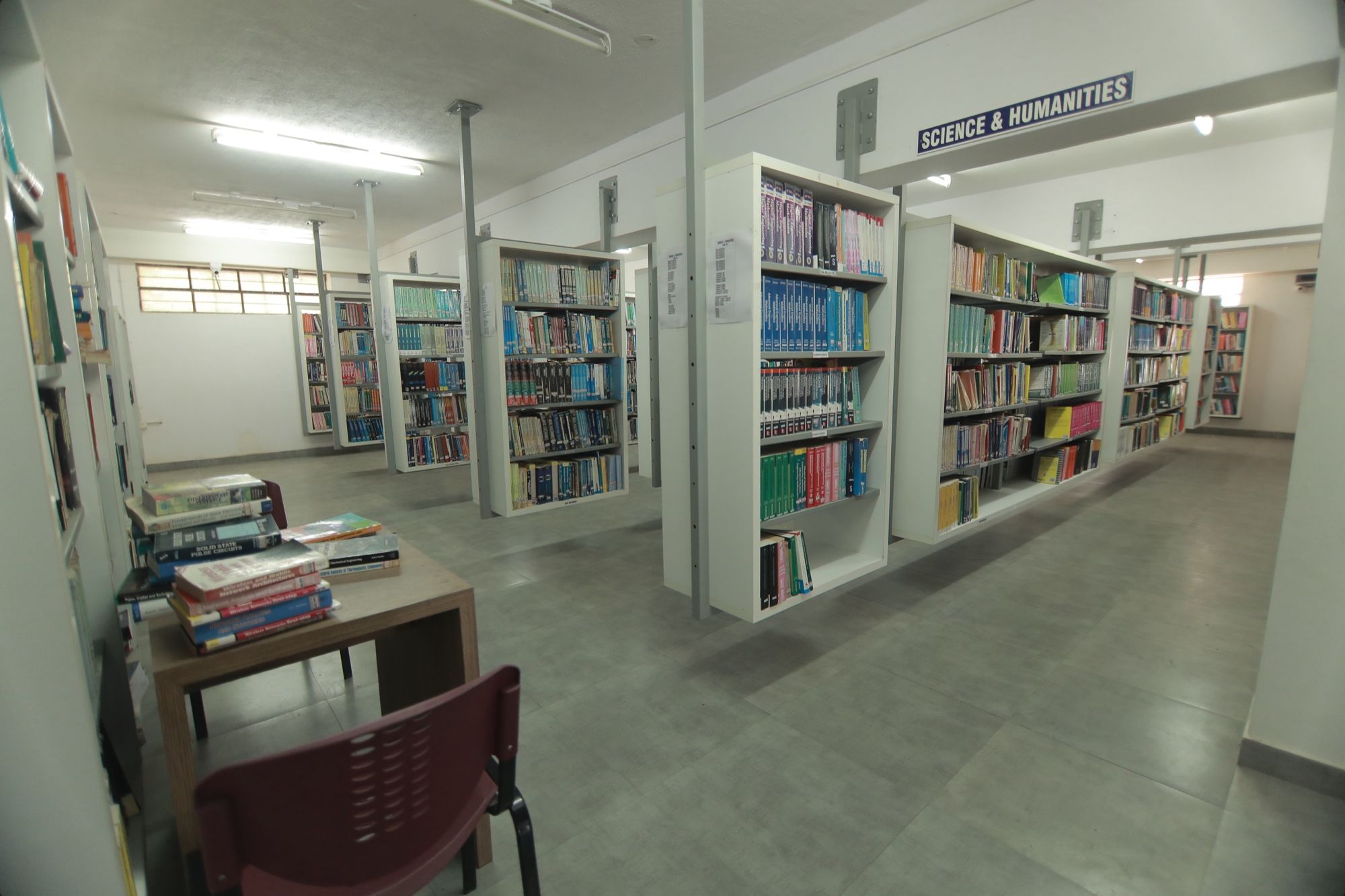 The Science & Humanities section of the PMC Tech central library, with shelves of books and a reading table