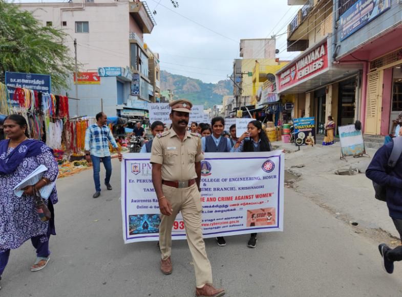 NSS volunteers walking behind their banner on a rally through a town street, a police officer beside it