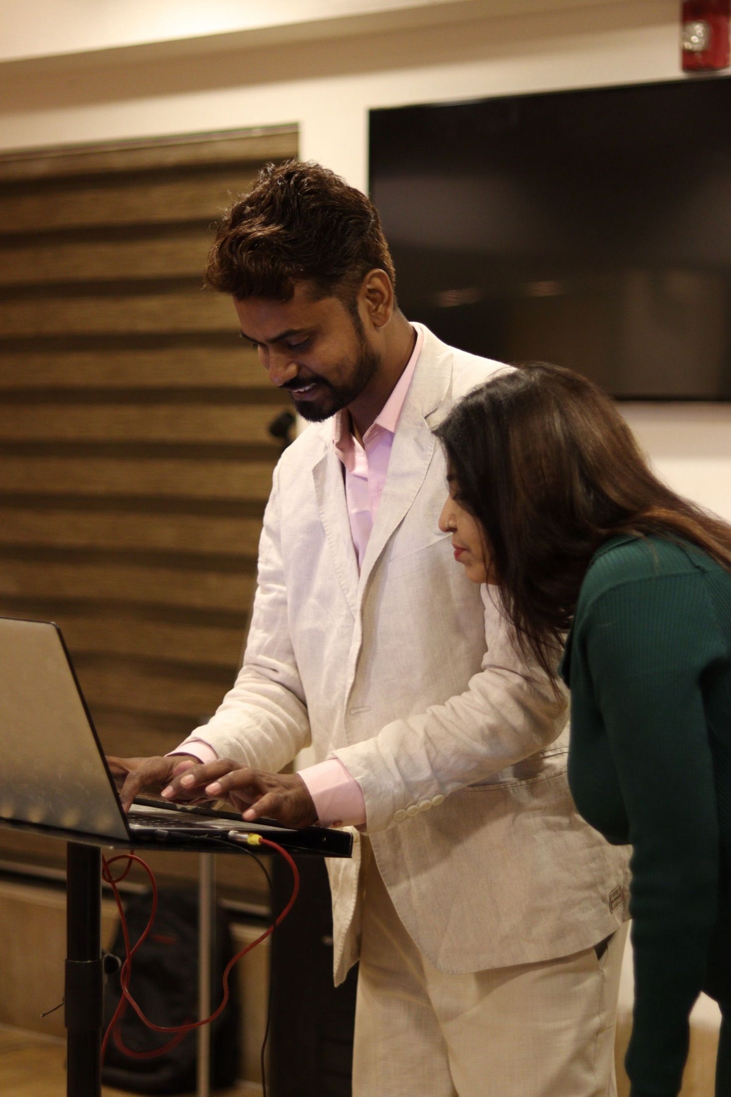 Two professionals reviewing work on a laptop in an office