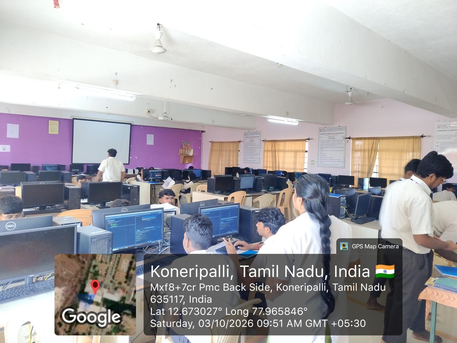 Programming & Computing Laboratory: students at desktop computers running code, in a room with a projector screen at the front.