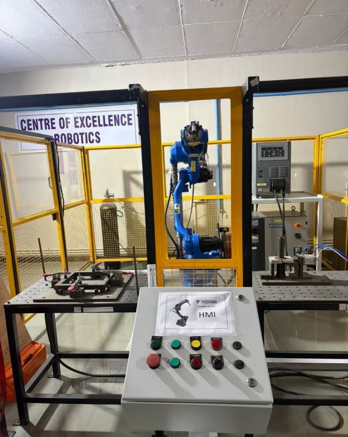 The Yaskawa welding robot in its fenced cell, under the Centre of Excellence in Robotics sign